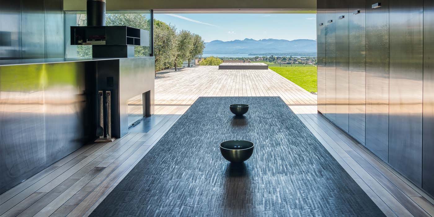 Espace de vie ouvert avec revêtement mural en acier inoxydable Nero HL et vue sur le paysage