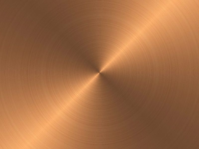 Surface métallique ronde avec une structure radiale brossée dans une teinte bronze.
