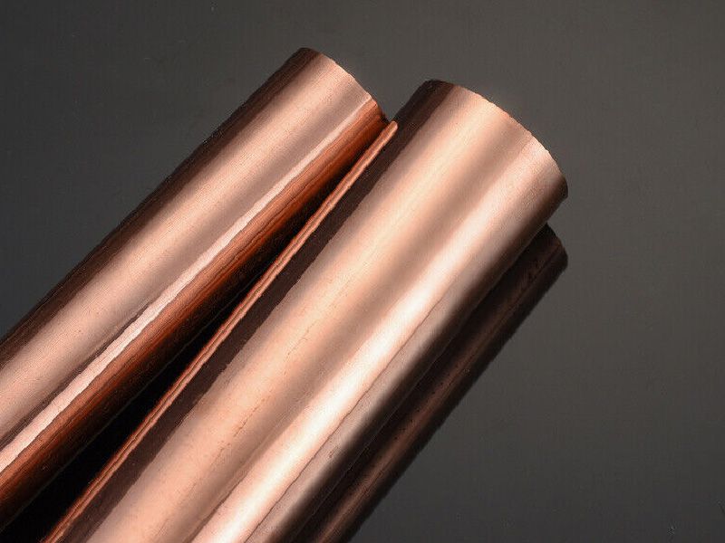Deux barres de cuivre massif à la surface lisse sur fond sombre