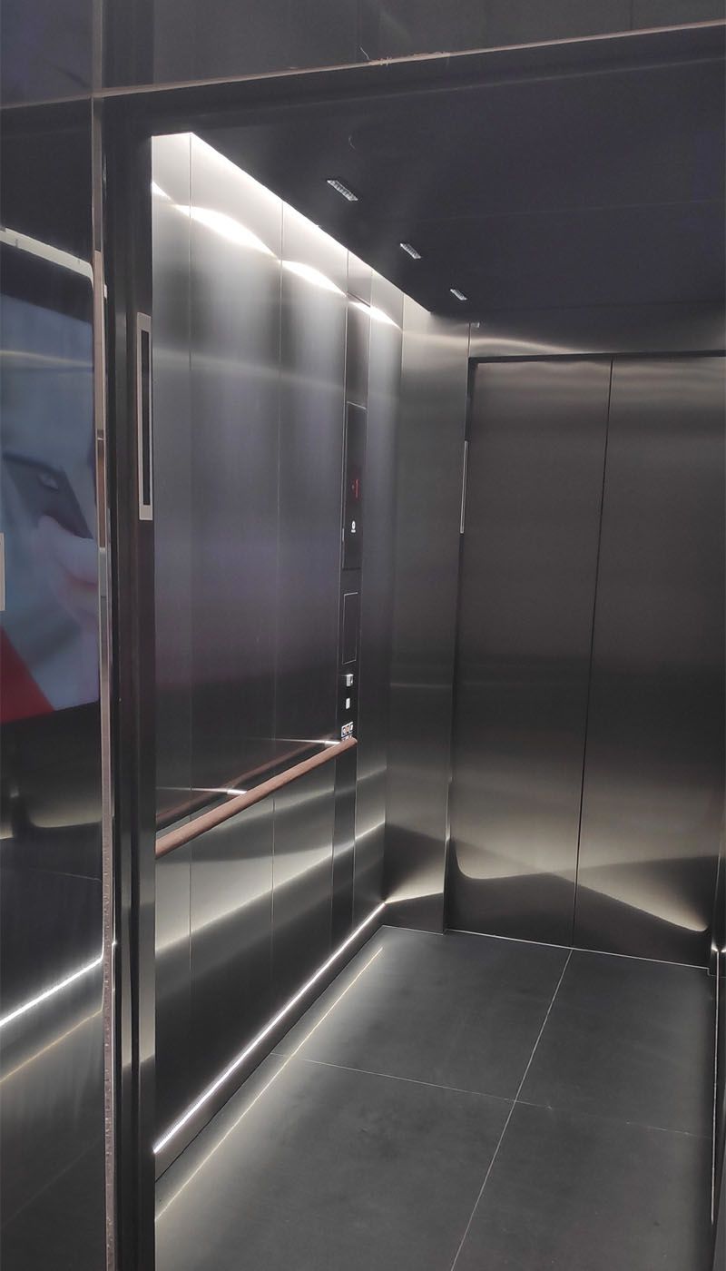 Vue intérieure de l’ascenseur multimédia avec parois en acier inoxydable satiné et éclairage LED intégré