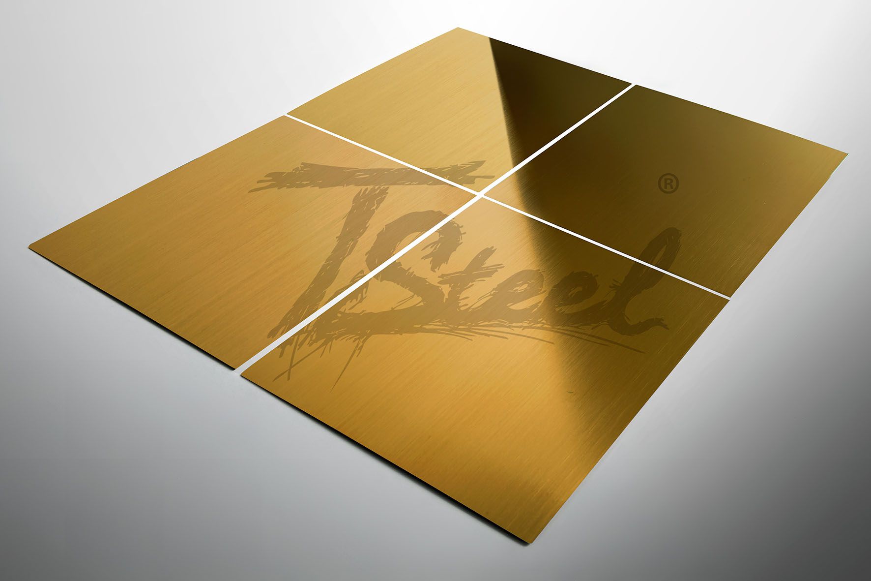 Quatre tôles carrées dorées en acier inoxydable avec surface brossée disposées sur fond clair