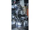 Polished stainless steel spheres and cylindrical elements in a workshop environment