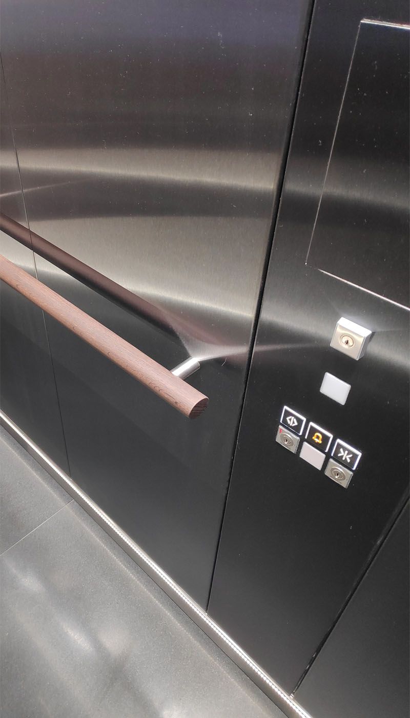 Vue intérieure de l’ascenseur multimédia avec main courante et panneau de commande en acier inoxydable Grigio Satinato